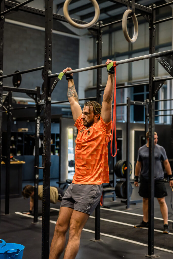 A man warming up on a CrossFit rig to avoid a CrossFit injury